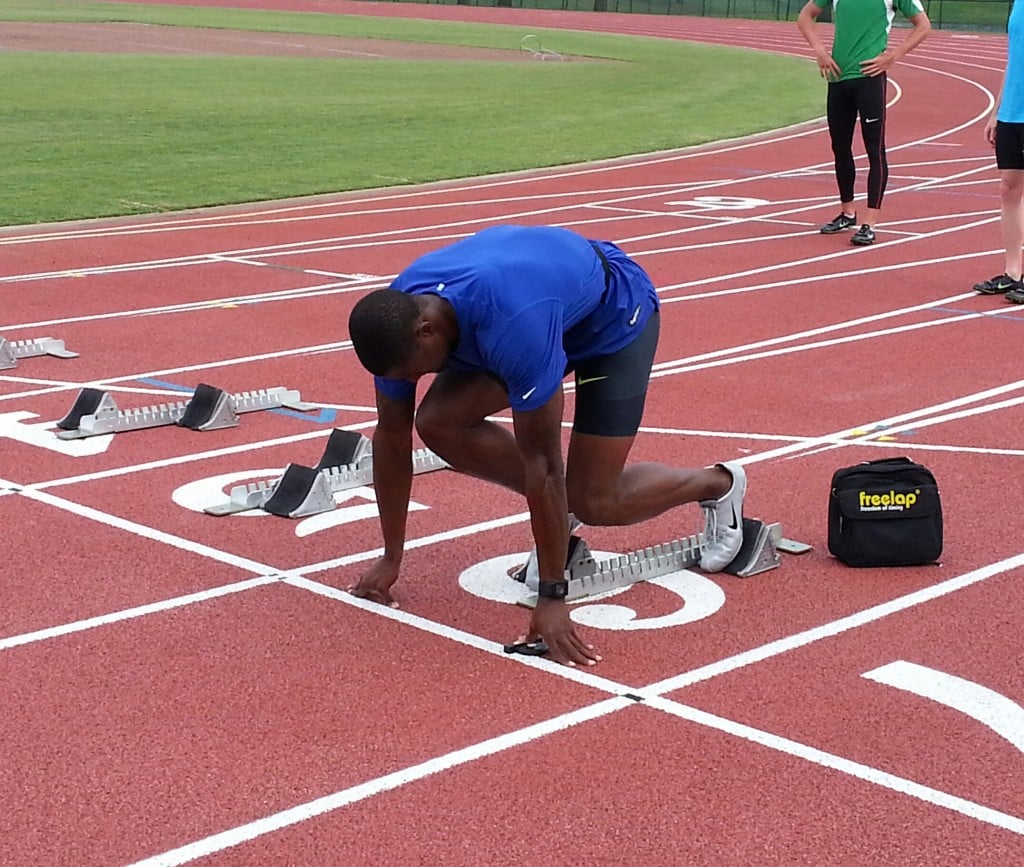 Olympic bronze medalist David Oliver sets up in the blocks with the Freelap Tx Touch transmitter.