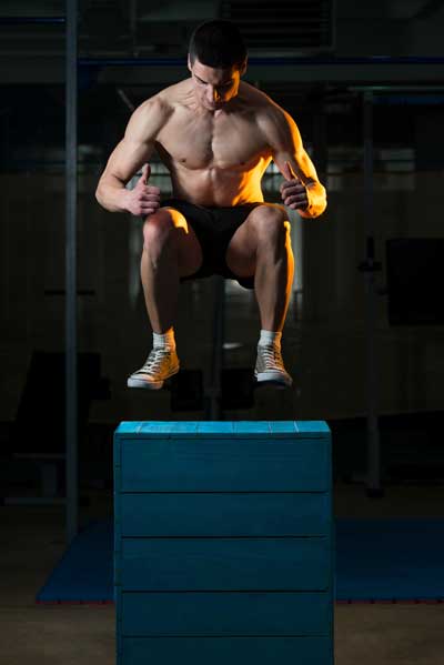 Figure 1: Athlete jumps up on the box with knees tucked for increased height.